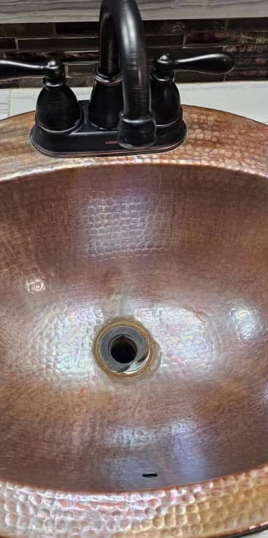 The same copper basin restored to a bright hammered finish