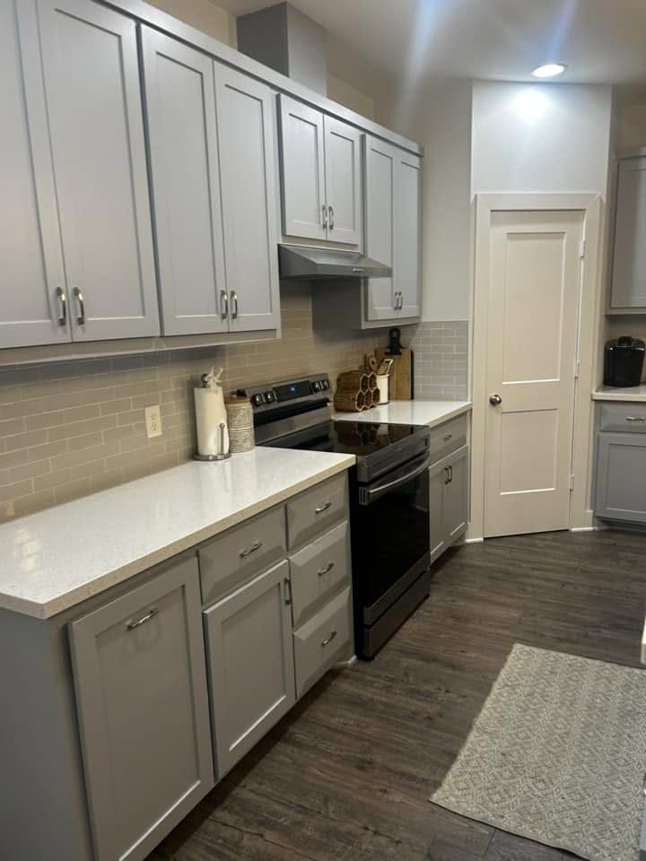 A clean kitchen with cleared counters and swept floors